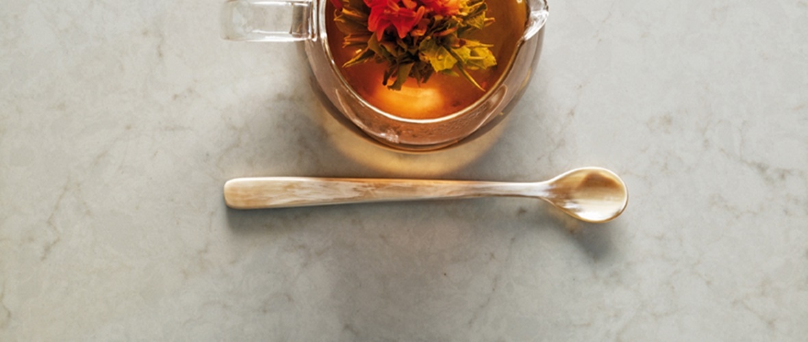 Teapot and spoon on a marble worktop surface